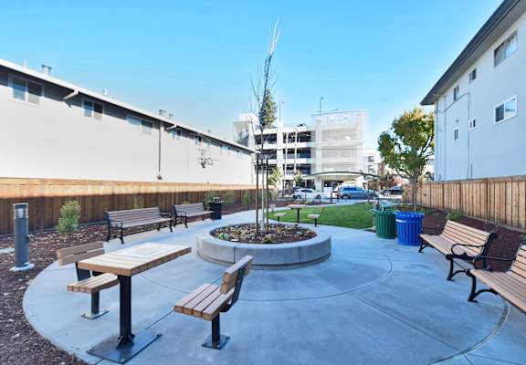 an outdoor seating area with benches and a fire pit