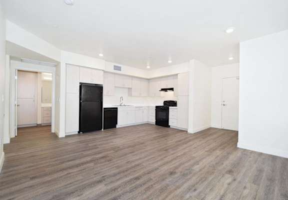 an empty room with white walls and wood floors