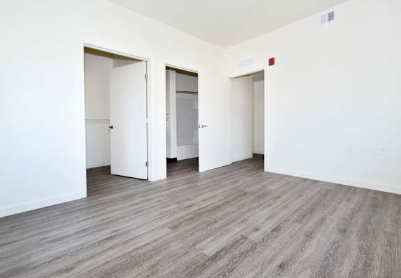 an empty living room with white walls and wood flooring