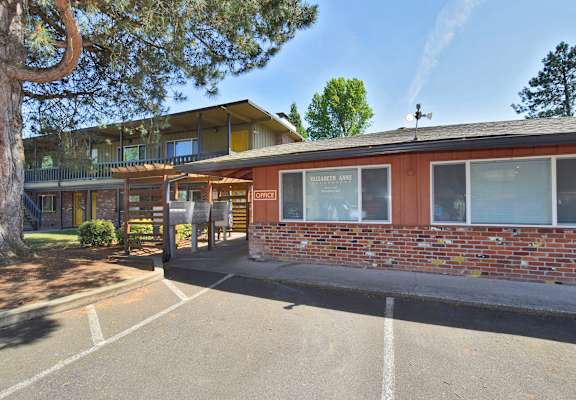 a brick building with a parking lot in front of it