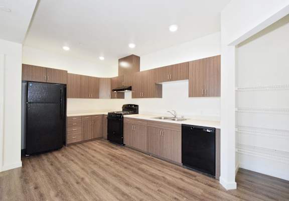 a kitchen with wood flooring and a black refrigerator
