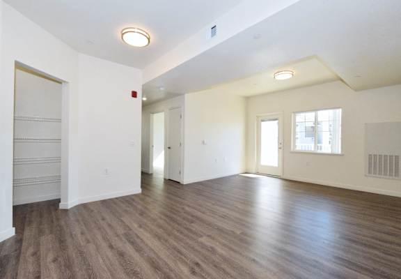 an empty living room with white walls and wood flooring
