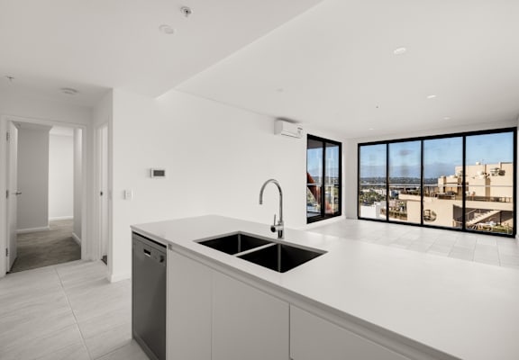 A modern kitchen with a large window overlooking a cityscape.