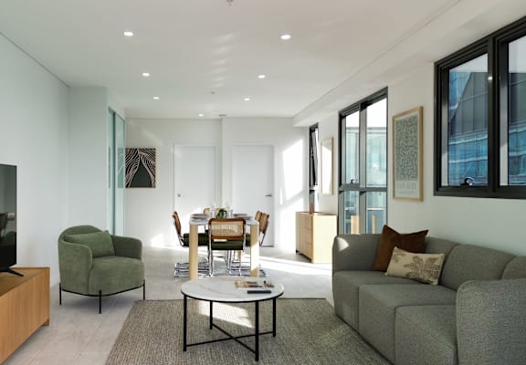 A living room with a grey couch, a green chair, and a coffee table.