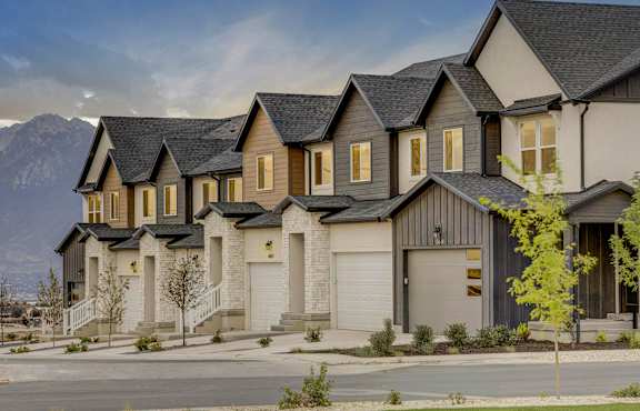 A row of houses with a mountain in the background at Mt. Rainier townhomes for rent in Herriman, Utah.