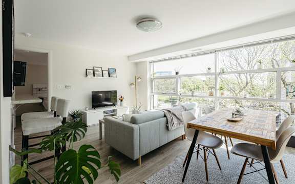 A living room with a couch, a chair, a table and a television.