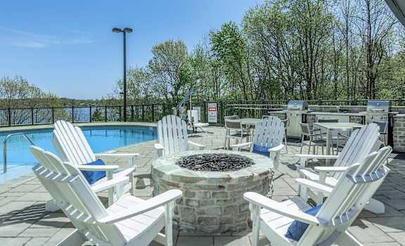 a patio with chairs and a fire pit and a pool