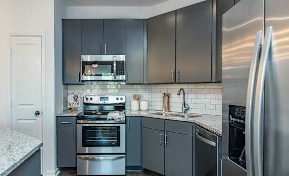 a kitchen with stainless steel appliances and gray cabinets