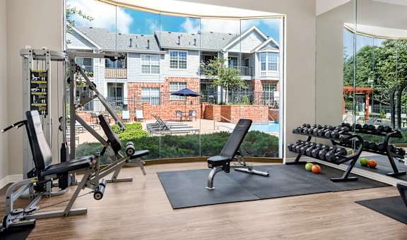 A gym with a view of a brick building across the street.