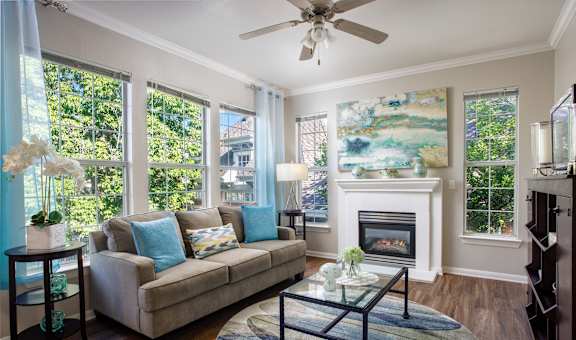 A living room with a couch, a fireplace, and a painting on the wall.