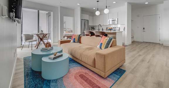 A living room with a couch, a coffee table, and a television.