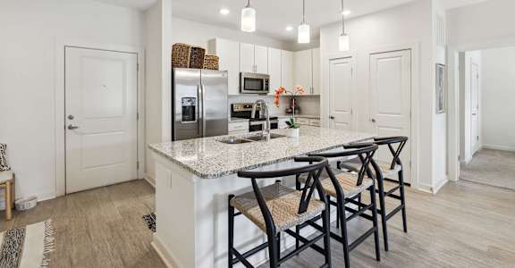 Kitchen with island and barstools at The Duke of Charleston apartments in Ladson, South Carolina
