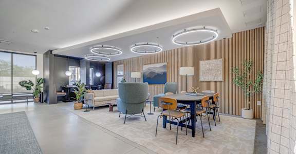 A modern dining area with a table set for six and a large window.