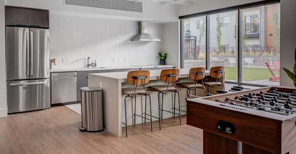 A modern kitchen with a bar area and a view of the backyard.