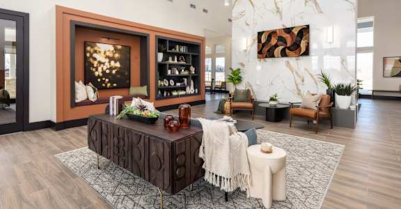 A modern living room with a wooden coffee table and a large painting on the wall at Montage at Hawk Ridge Apartments, Lake St. Louis, Missouri, 63367