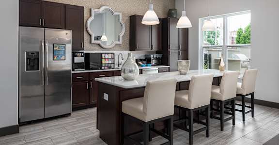 A modern kitchen with a large island and chairs.