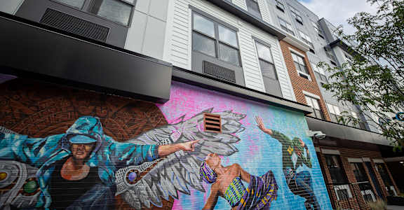 A mural of a person with wings is painted on the side of a building at Walnut View Apartments, Allentown, PA, 18102