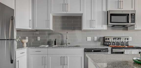 a kitchen with white cabinets and granite counter tops