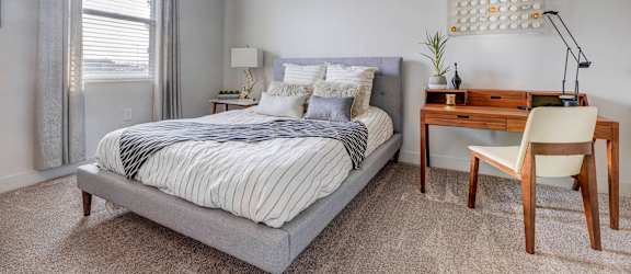a bedroom with a bed and a desk with a chair