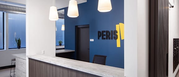 a reception area with a blue wall and a counter with a desk and chairs