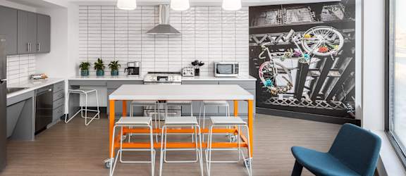 a kitchen with a white table and orange stools
