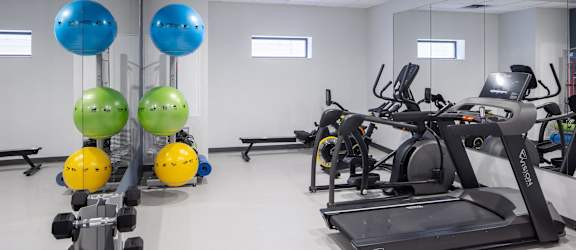 a gym with exercise equipment and weights in a treatment room