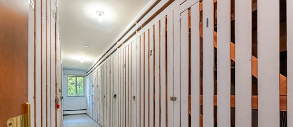 A long hallway with a door on the left and numbered doors on the right.