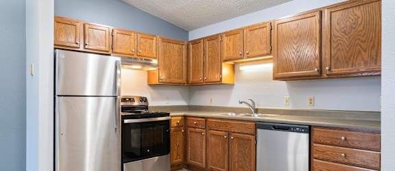 A kitchen with wooden cabinets and stainless steel appliances.