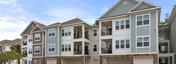 A large, modern apartment building with multiple garages and balconies.