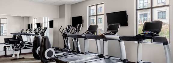 A gym with treadmills and exercise bikes.