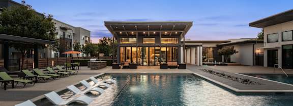 A modern house with a pool in front.