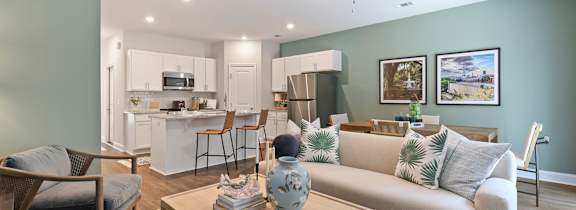 A living room with a grey couch, a coffee table, and a ceiling fan.
