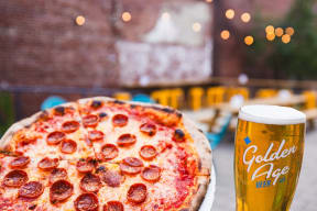a pizza and a glass of beer on a table