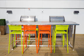 A table with four chairs in yellow, orange and green.