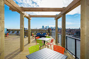 A wooden deck with a table and chairs overlooking a city skyline.