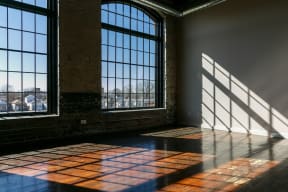 an empty room with large windows and shadows on the floor