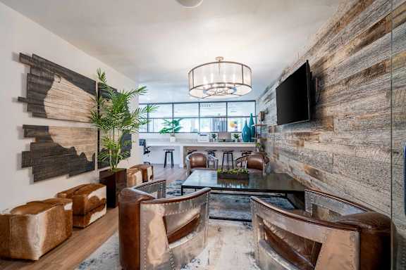 A modern living room with a wooden accent wall and a flat screen TV mounted on it.