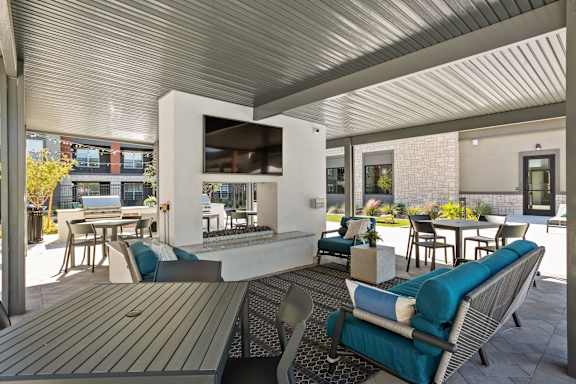A patio with a table and chairs and a television.