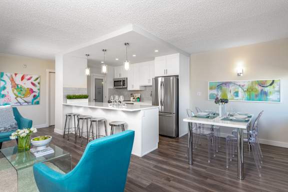 a living room and kitchen with a dining table and chairs