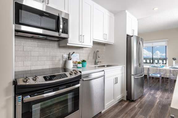 a kitchen with stainless steel appliances and white cabinets