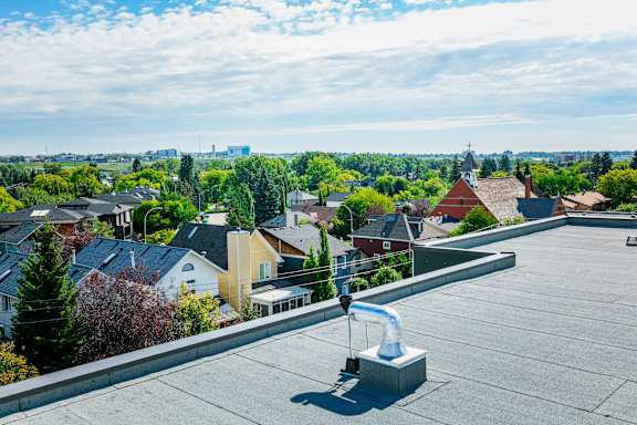 A rooftop view of a residential area with houses and trees.