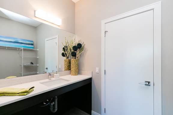 A bathroom with a white sink and a white door.
