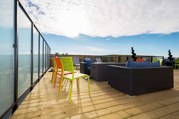 A balcony with a table and chairs overlooking the ocean.