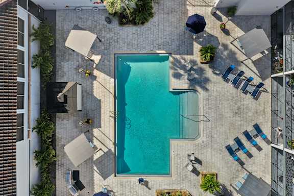 a pool is surrounded by chairs and umbrellas