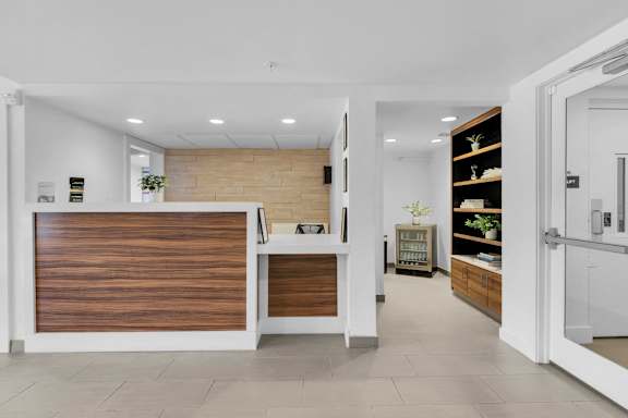 a reception area with a wooden reception desk and a door