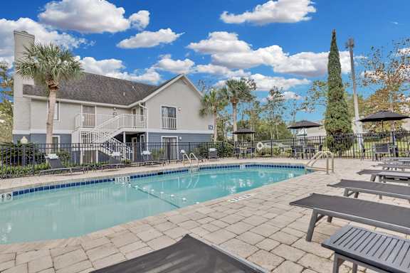 the preserve at ballantyne commons pool and patio area with tables and a building