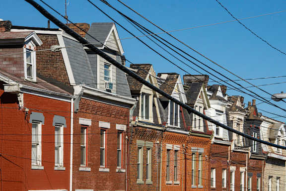 A row of houses with different colored roofs.