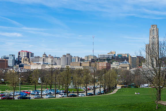 A city skyline with a tall tower stands out against the sky.