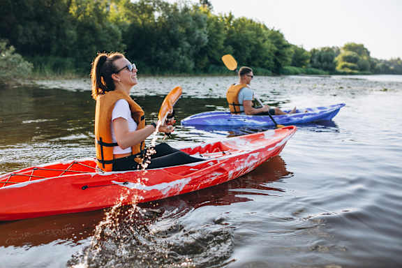 Two people kayaking on a river.
