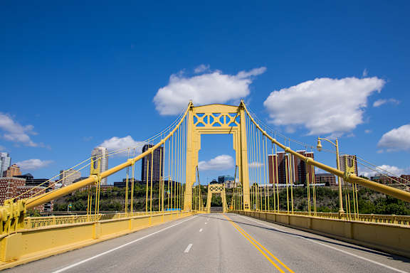A yellow bridge with a clear blue sky in the background.
